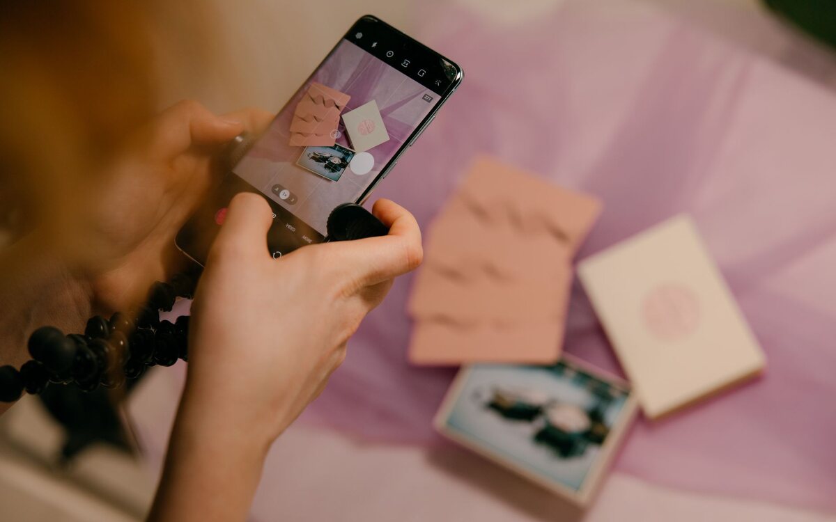 Artesã usando o celular ao lado das peças